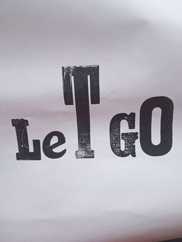 Print of black letters on white saying Let Go.